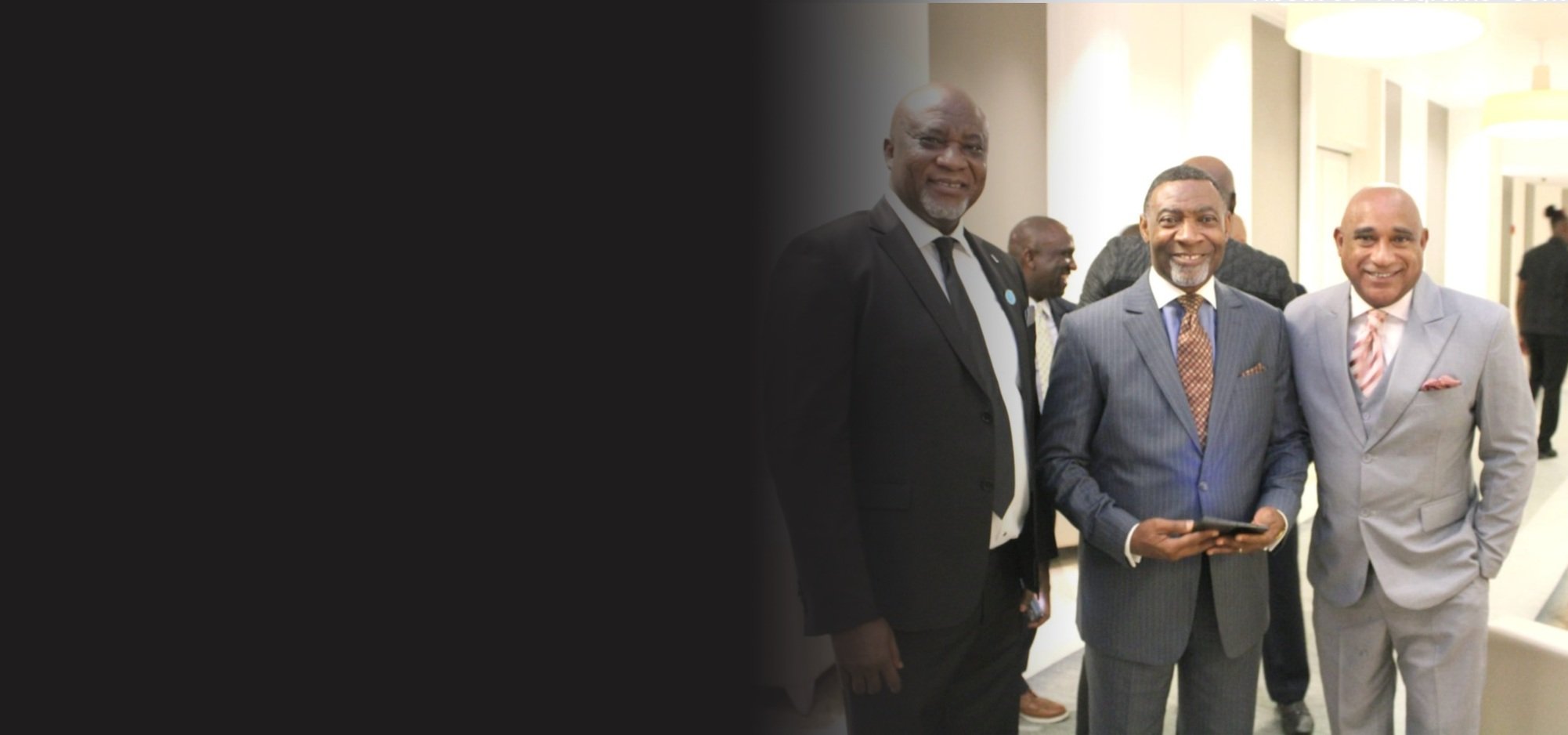 The Honorable Dr. Adrian Fox smiling with 2 additional men.